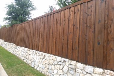 Board on Board Fence with Stone Retaining Wall in Prosper, TX