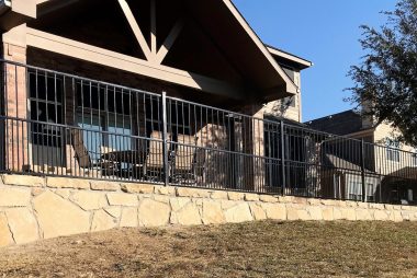 Stone Retaining Wall with Galvanized Steel Fence in Fort Worth, TX
